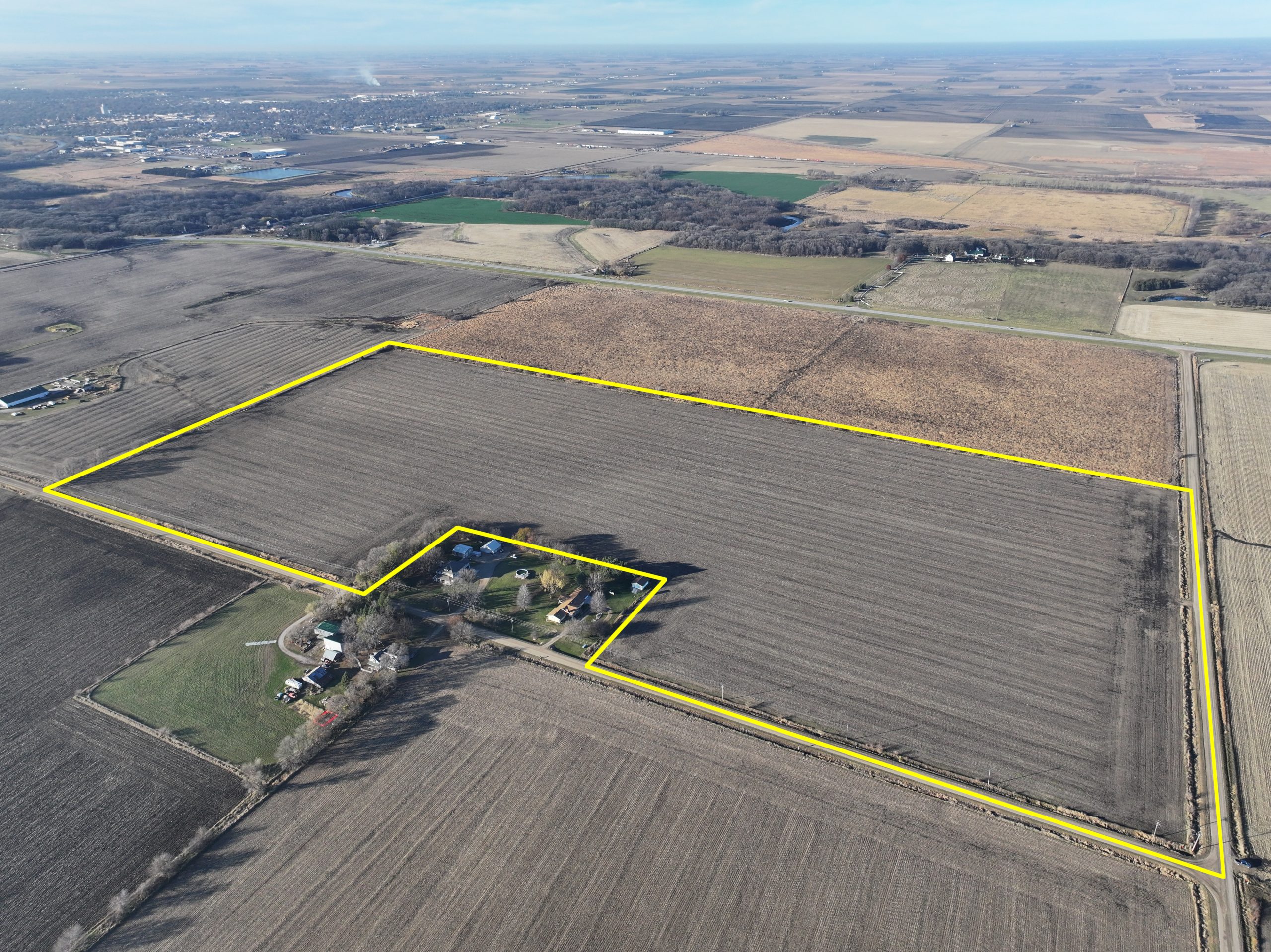Aerial view of farmland with a house and highlighted property boundaries.