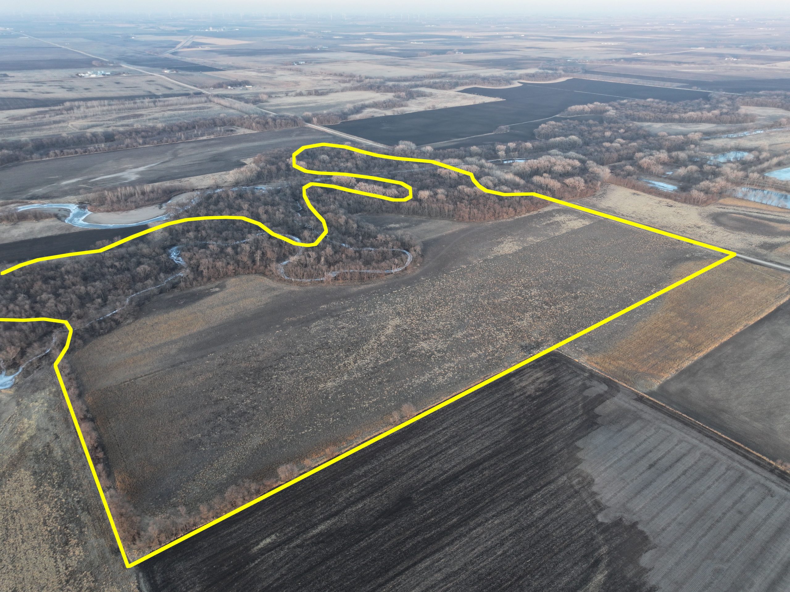Aerial view of farmland with a yellow outline indicating property boundaries.