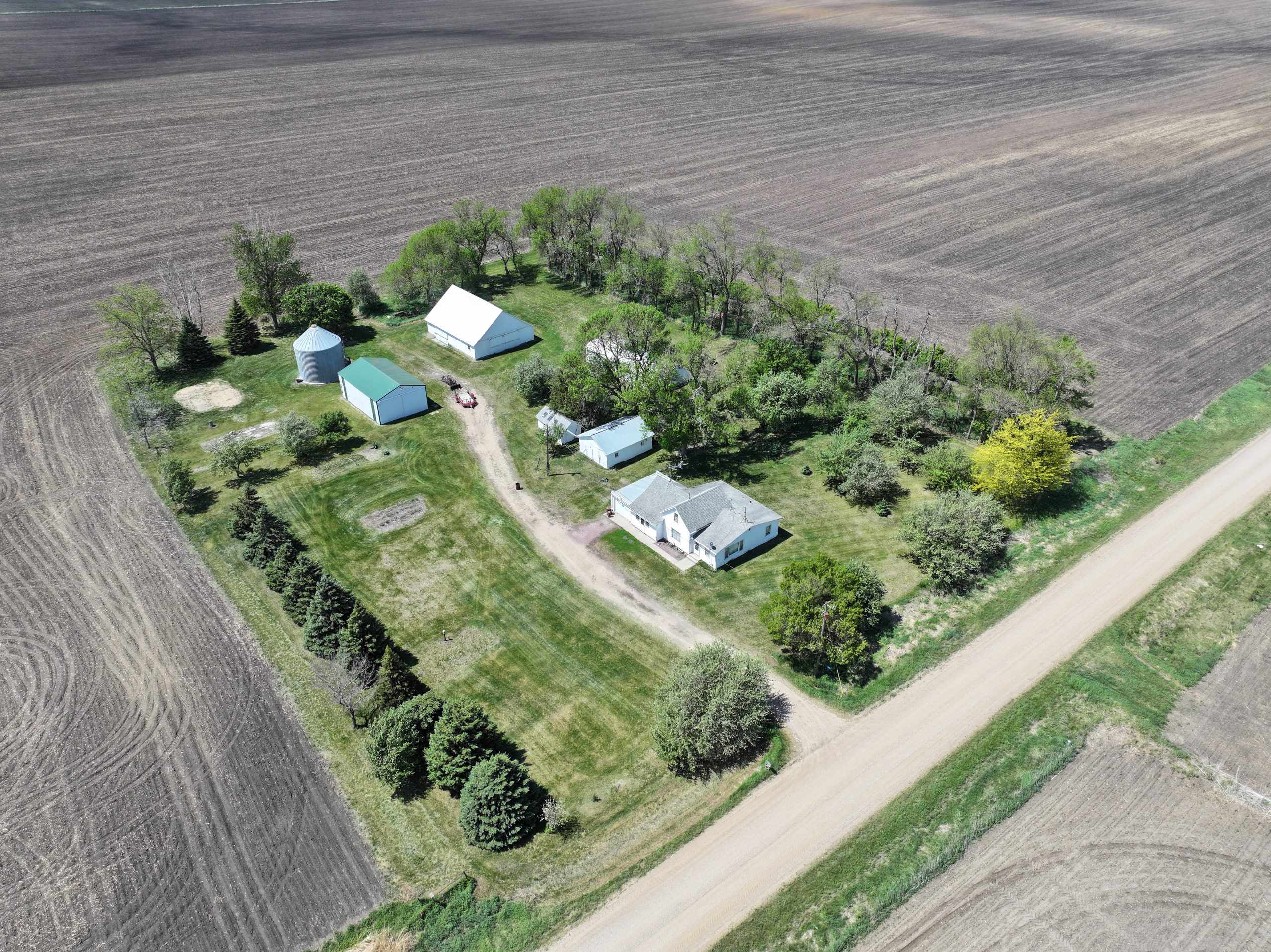 Aerial view of a farmhouse, outbuildings, and surrounding farmland.