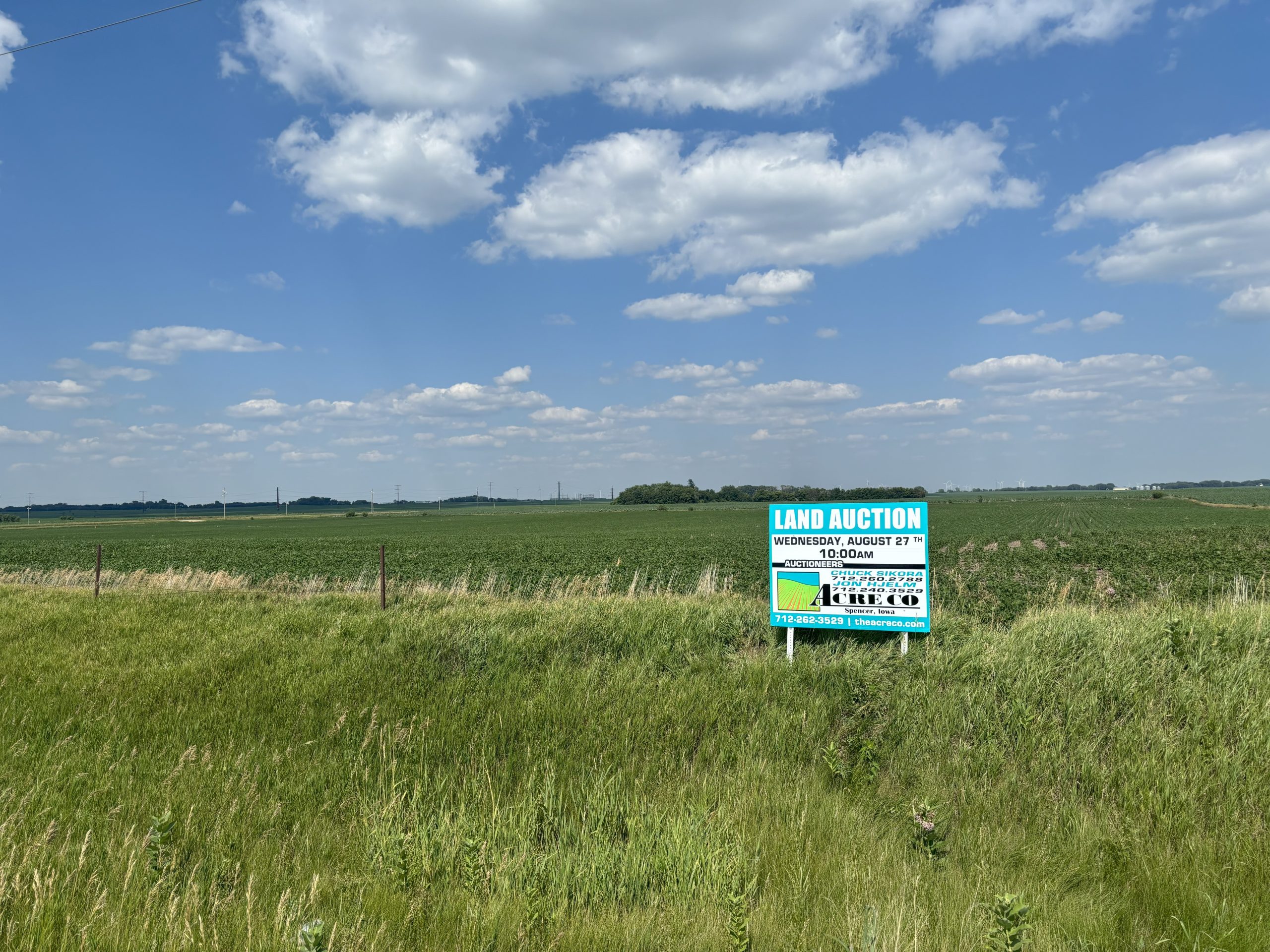Land auction sign in a rural Iowa field.